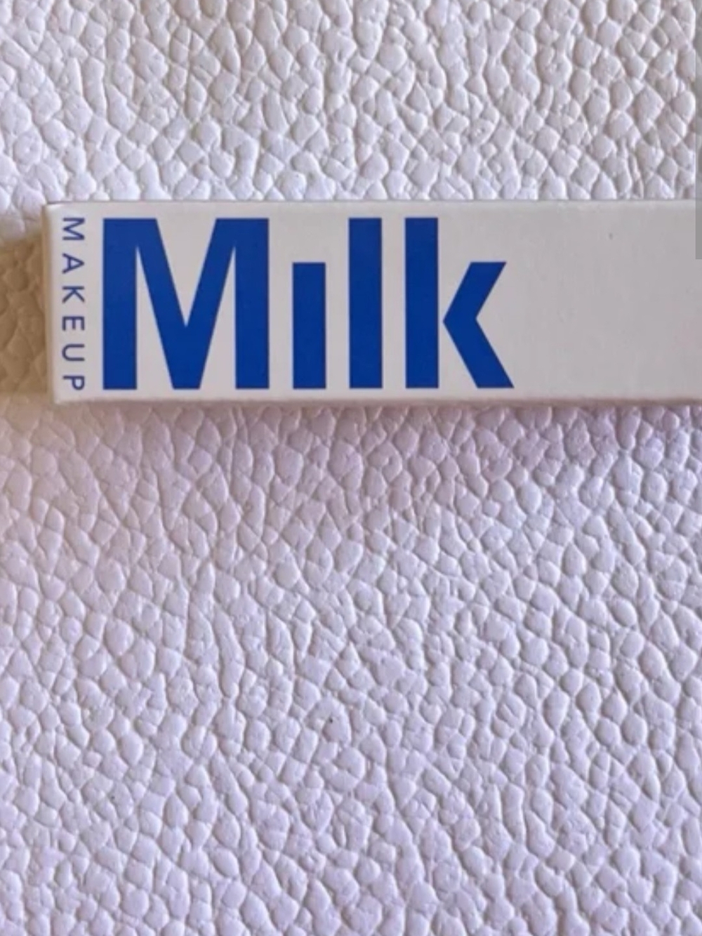 Milk Makeup White Packaging with Bold Blue Logo